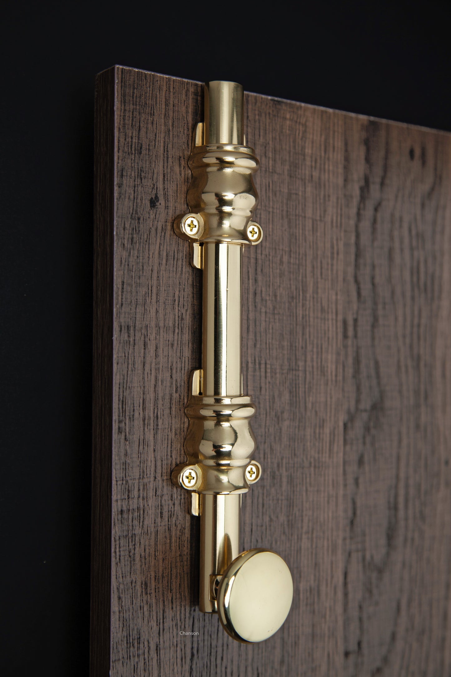 Lifestyle image for 8 inch solid brass surface bolt with ornate, ornamental, or colonial style guides.  Surface bolt is mounted on a door with finish matching screws.