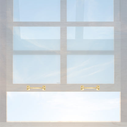 A wooden sash window with a pair of chanson hardware larger, 4 inch center to center solid brass bar type sash lifts in polished brass finish