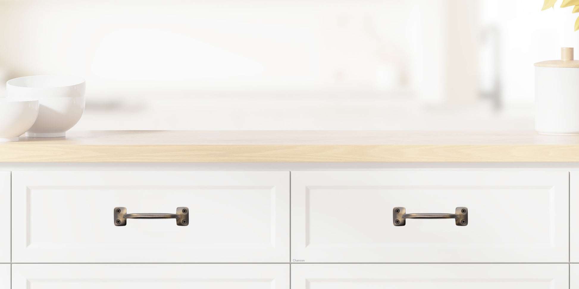 Chanson Hardware larger 4 inch center to center solid brass drawer pull shown on drawer front with antique brass finish