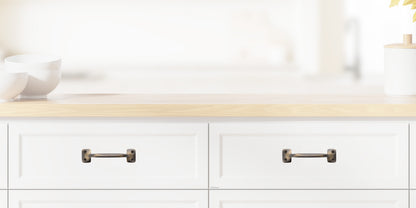 Chanson Hardware larger 4 inch center to center solid brass drawer pull shown on drawer front with antique brass finish