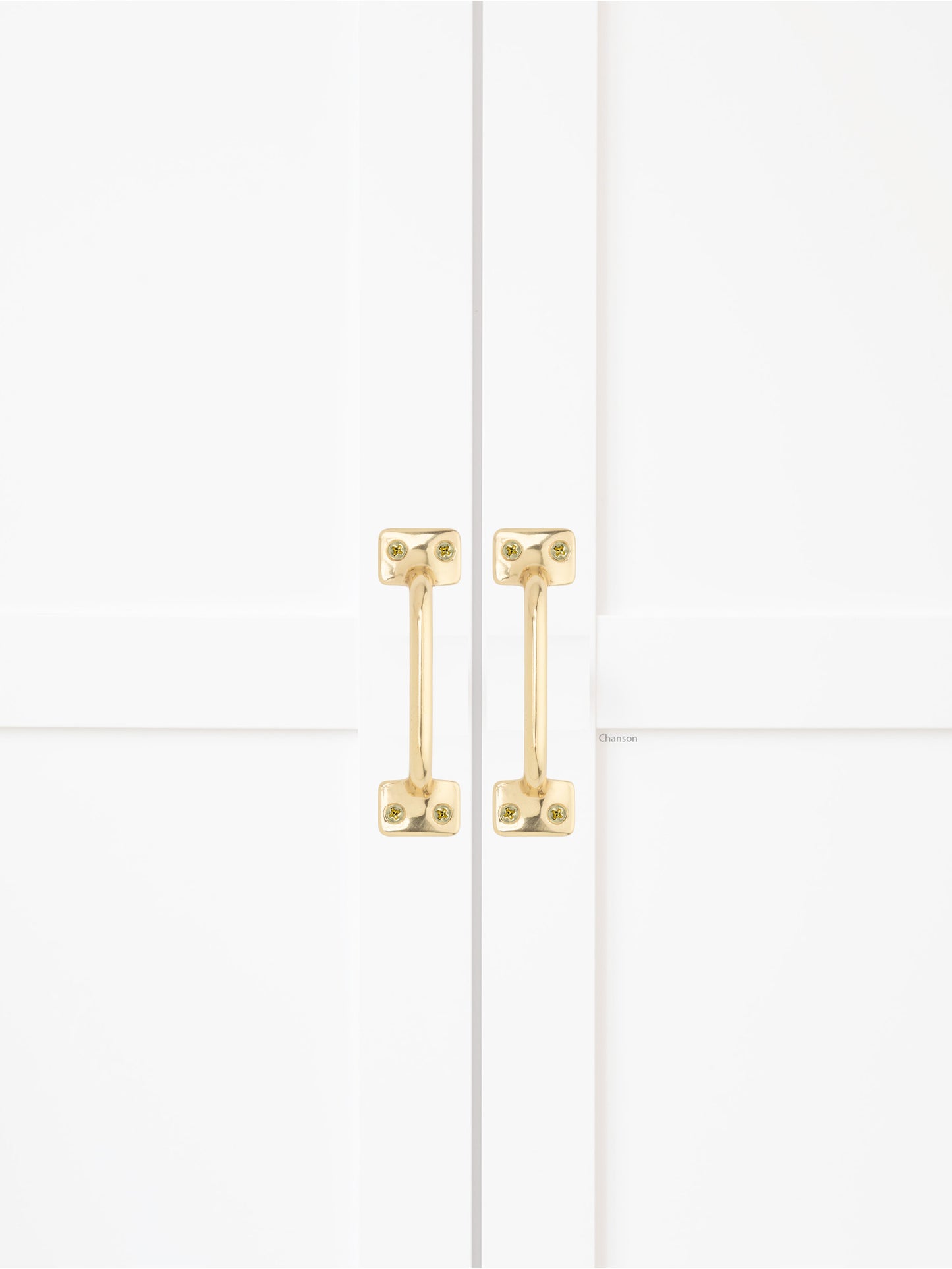 Chanson Hardware solid brass door pull shown on cabinet door in polished brass finish