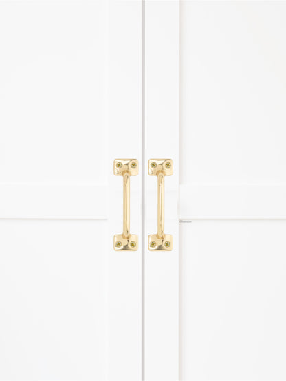 Chanson Hardware solid brass door pull shown on cabinet door in polished brass finish