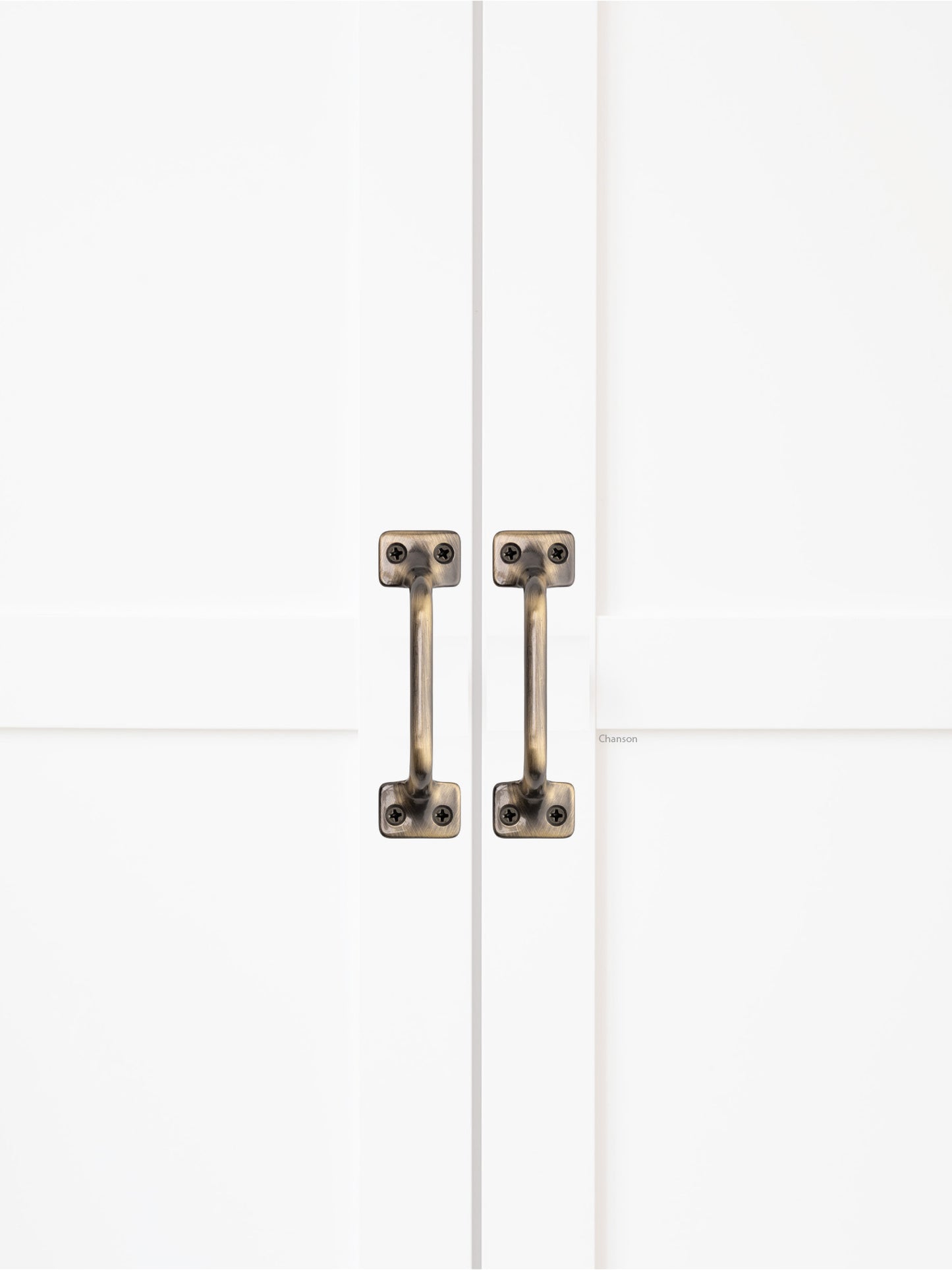 Chanson Hardware solid brass door pull shown on cabinet door in antique brass finish