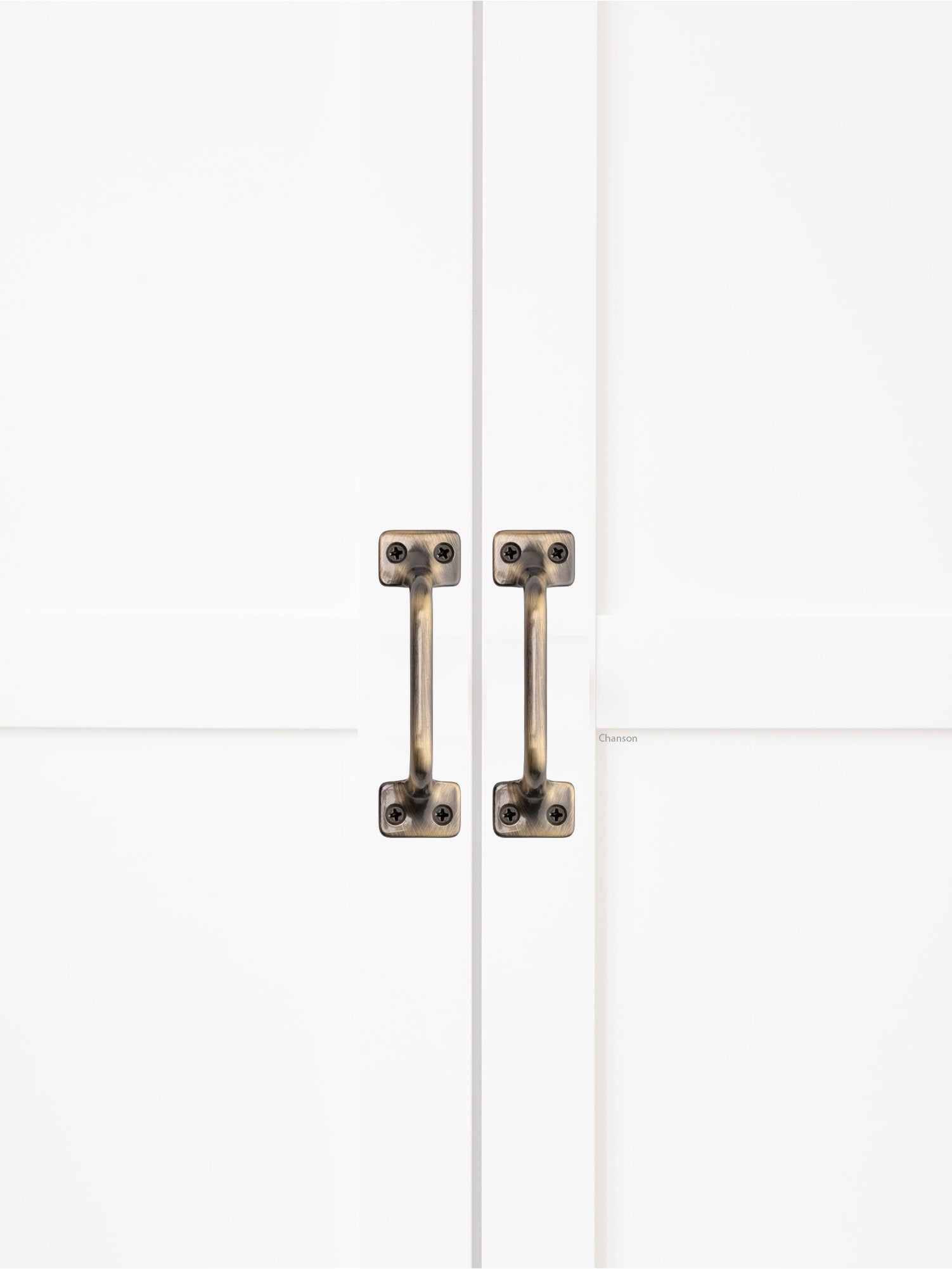 Chanson Hardware solid brass door pull shown on cabinet door in antique brass finish