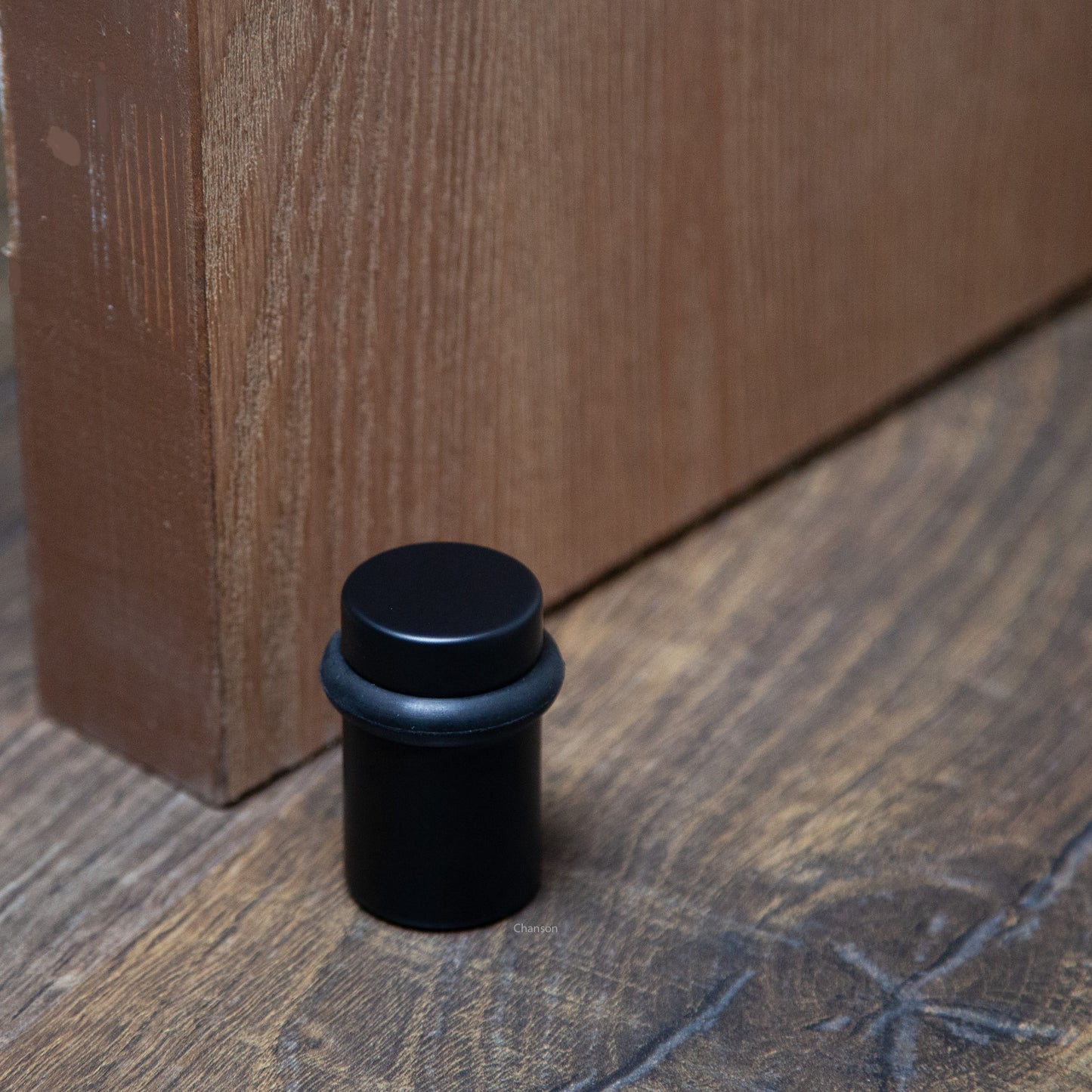 Lifestyle image for chanson hardware 2 inch solid brass cylindrical floor doorstop in flat or matte black finish US19