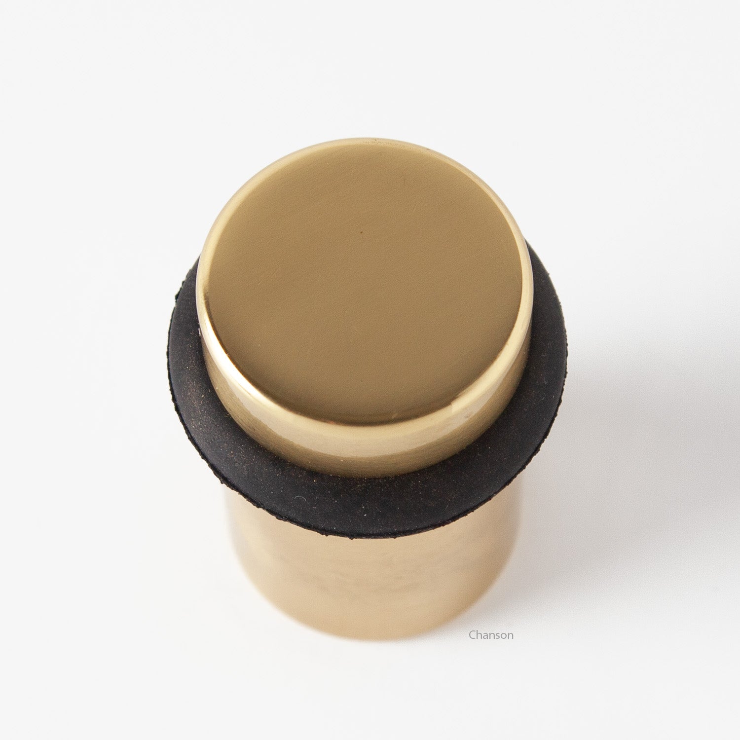 Top view of flat top solid brass cylindrical round floor doorstop in polished brass finish US3