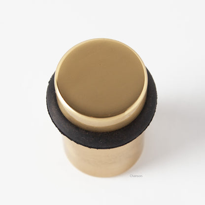 Top view of flat top solid brass cylindrical round floor doorstop in polished brass finish US3