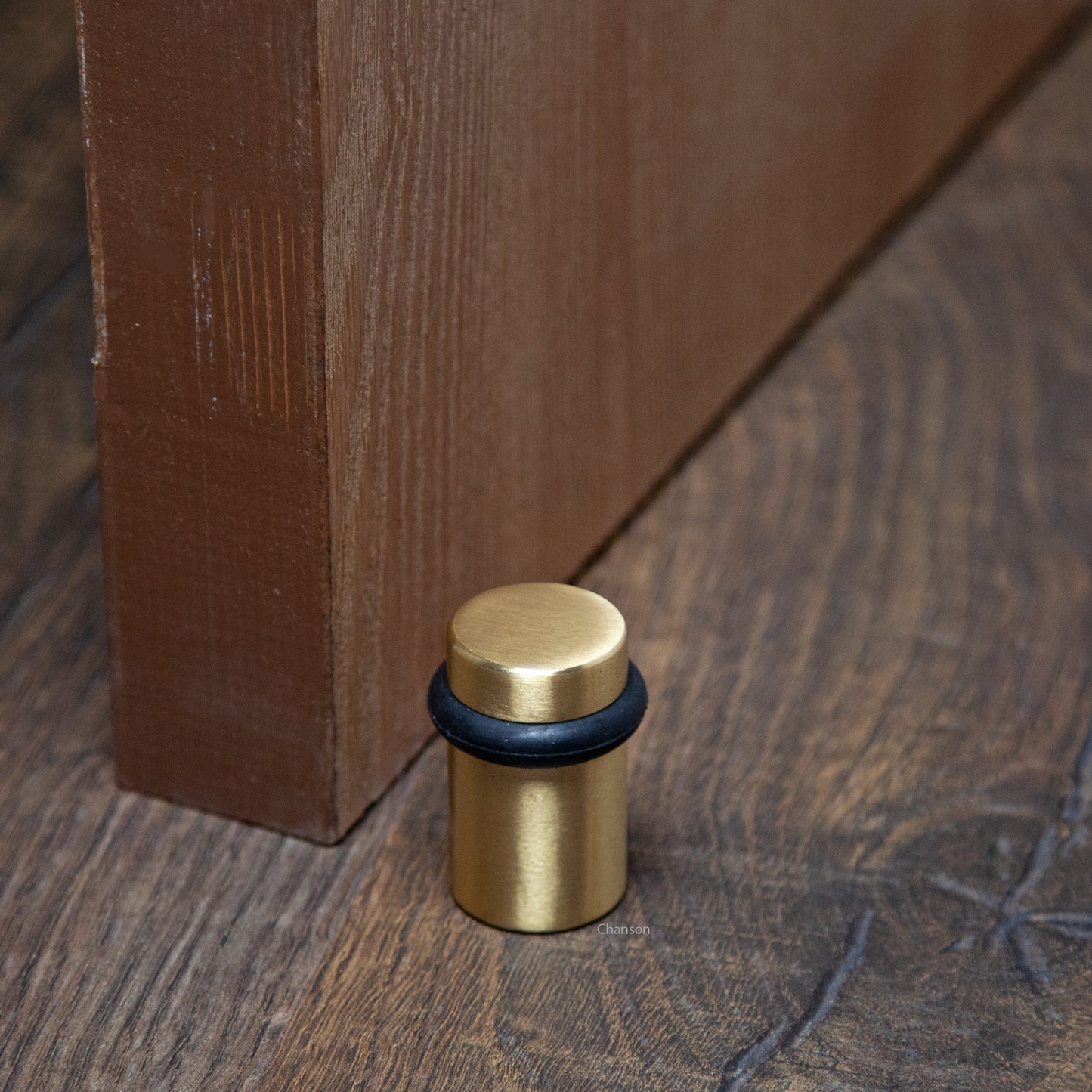 Lifestyle image for chanson hardware 2 inch solid brass cylindrical floor doorstop in satin brass finish US4
