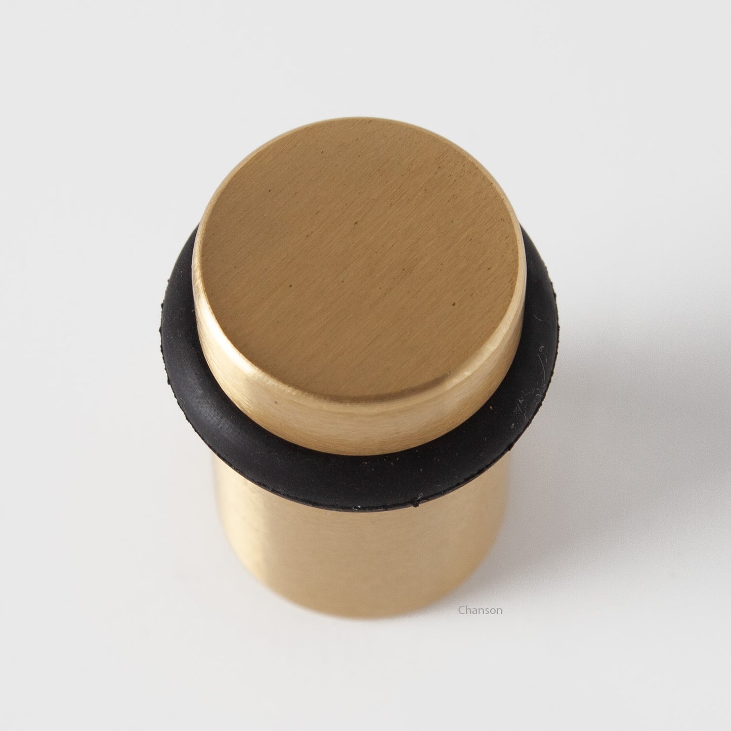 Top view of flat top solid brass cylindrical round floor doorstop in satin brass finish US4