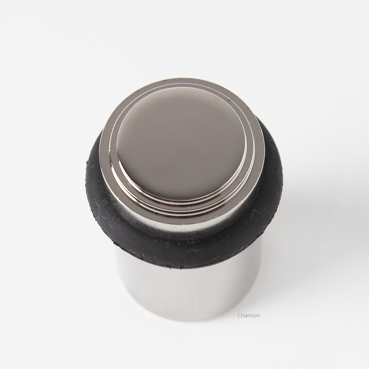top view of chanson hardware tiered top solid brass doorstop that shows stepped design and cylindrical shape. Finish is polished nickel US14.  Inspired by Art Deco
