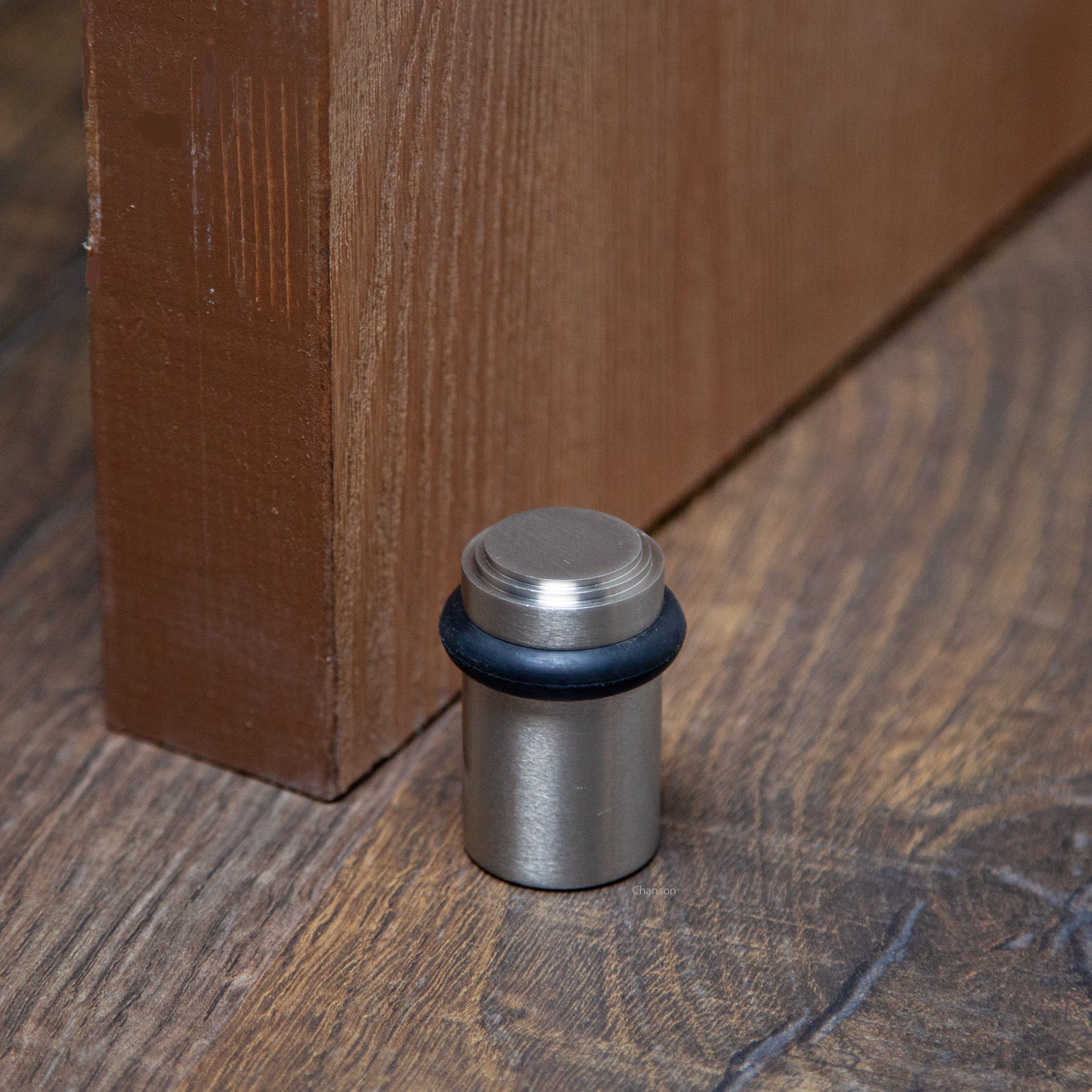 Lifestyle photo for chanson hardware solid brass tiered top floor doorstop, which shows stepped or art deco inspired design and satin or brushed nickel US15 finish.