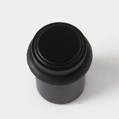 top view of chanson hardware tiered top solid brass doorstop that shows stepped design and cylindrical shape. Finish is flat or matte black US19.  Inspired by Art Deco
