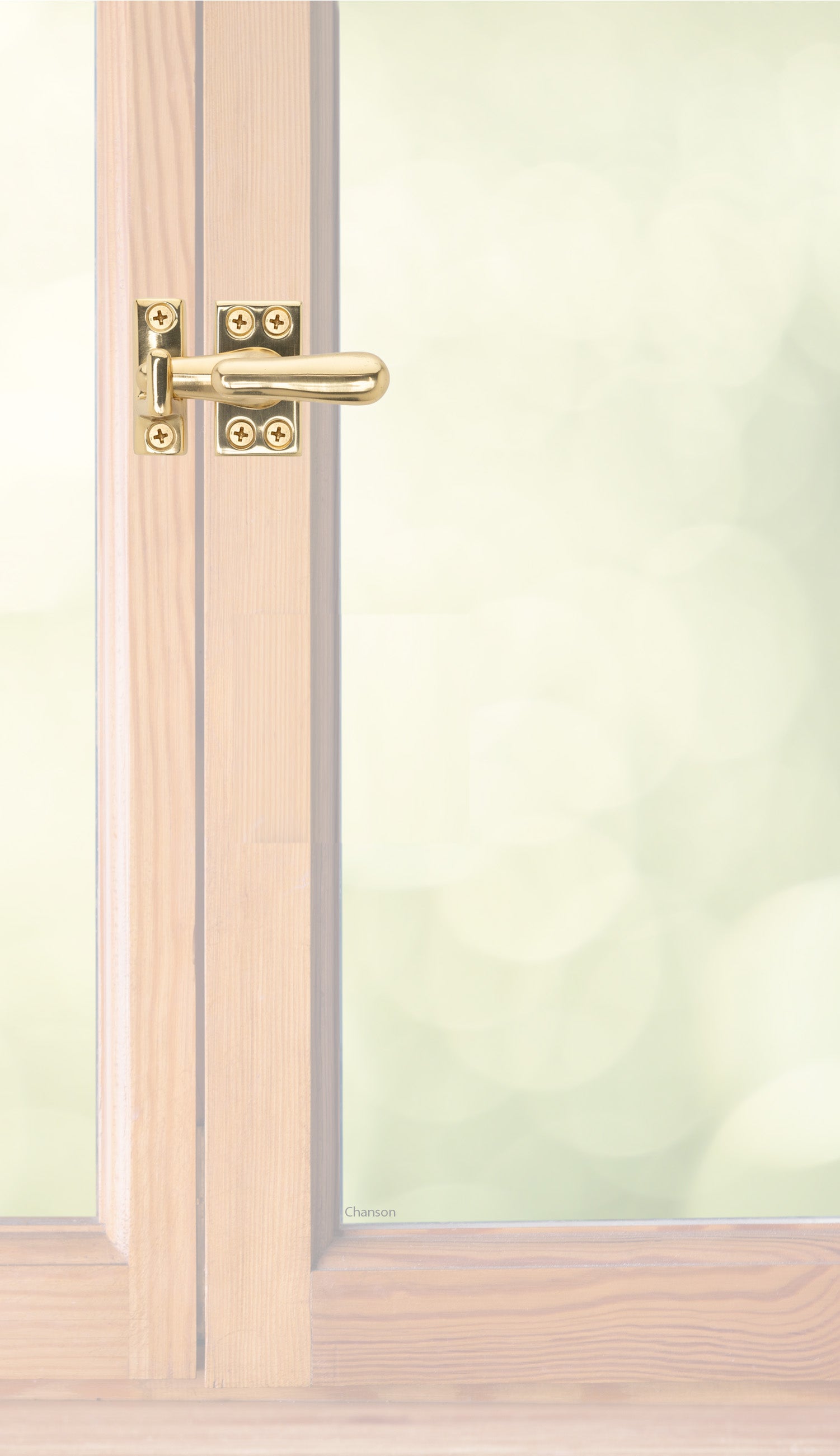 Traditional style solid brass casement fastener or window latch with a surface strike installed on a wooden swinging window, shown with polished brass finish