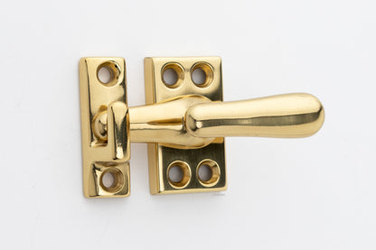 Forged solid brass casement fastener latch unit engaged with surface strike in polished brass finish US3