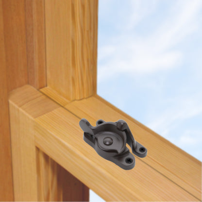 A wooden sash window, single or double hung, with a large solid brass sash catch or latch installed on the meeting rail, shown in oil rubbed bronze finish