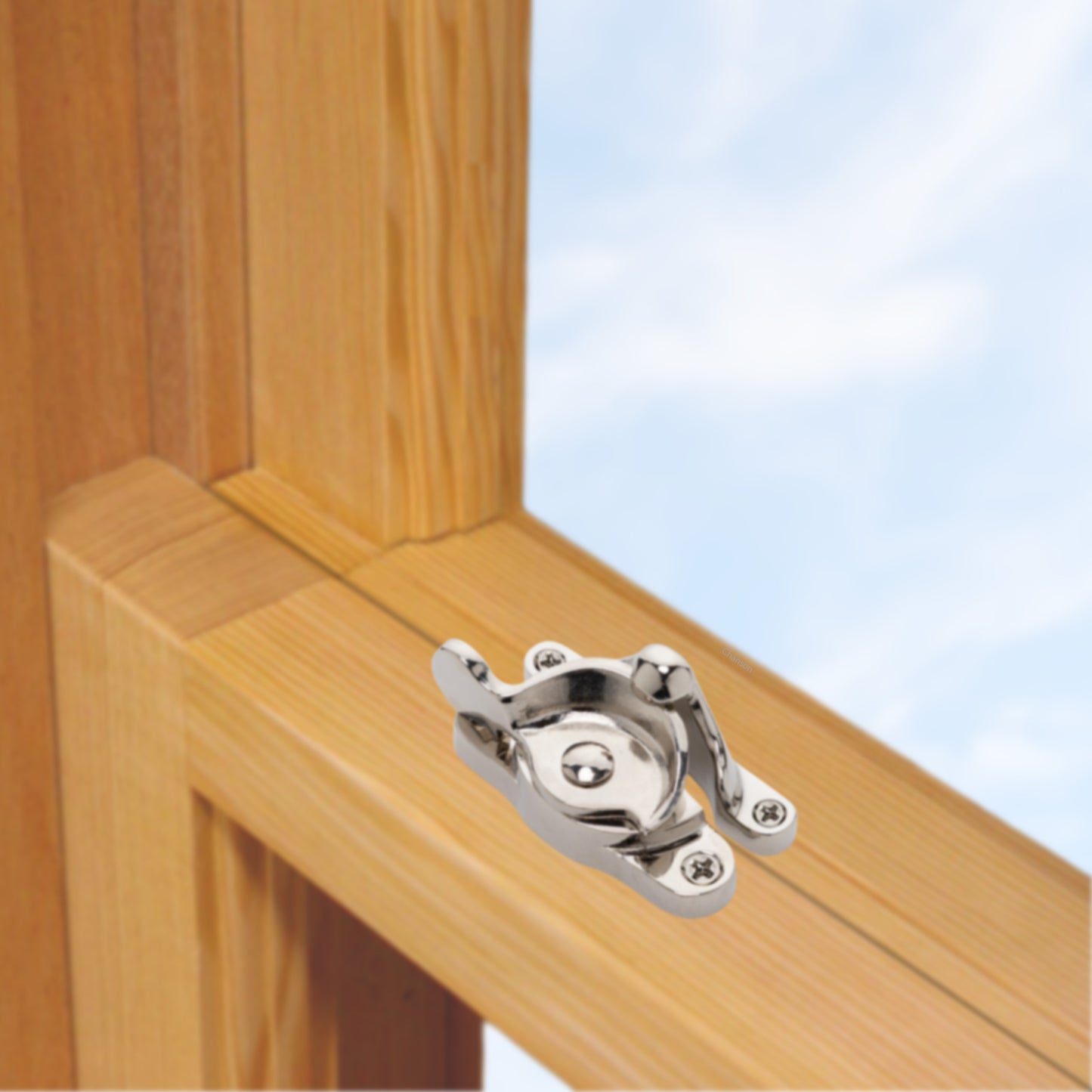 A wooden sash window, single or double hung, with a large solid brass sash catch or latch installed on the meeting rail, shown in polished nickel finish