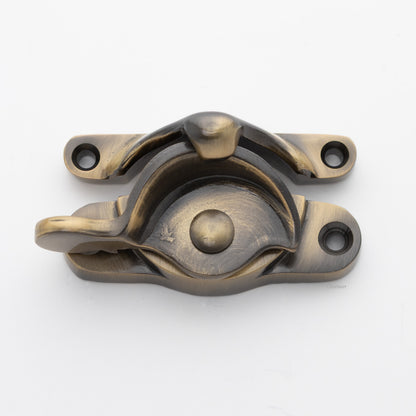 Classic or traditional large solid brass sash catch or sash window lock with hook style keeper and crescent shape in antique brass US5 finish