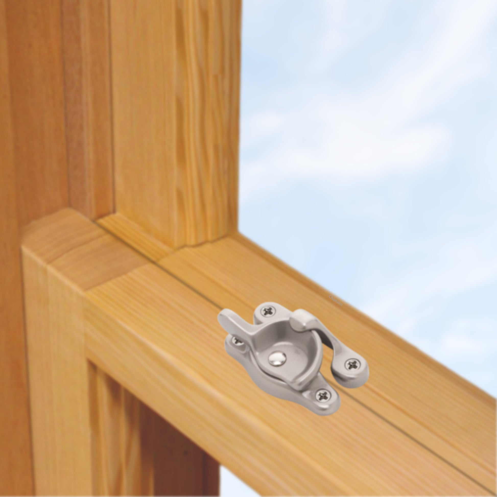A wooden sash window, single or double hung, with a solid brass sash catch or latch installed on the meeting rail, shown in satin nickel finish