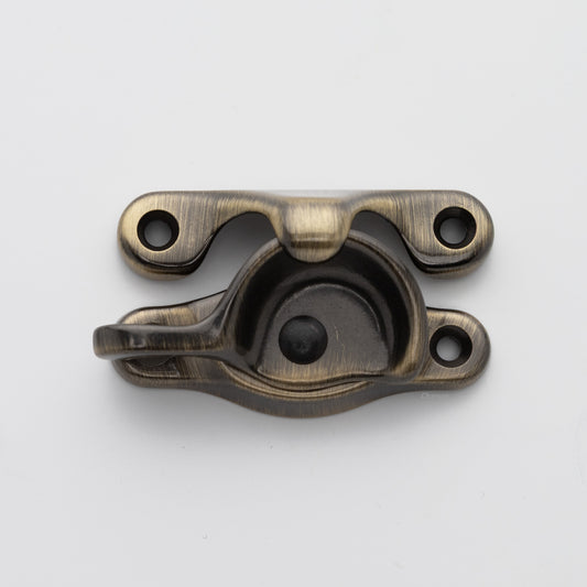 Classic or traditional solid brass sash catch or sash window lock with hook style keeper and crescent shape in antique brass US5 finish