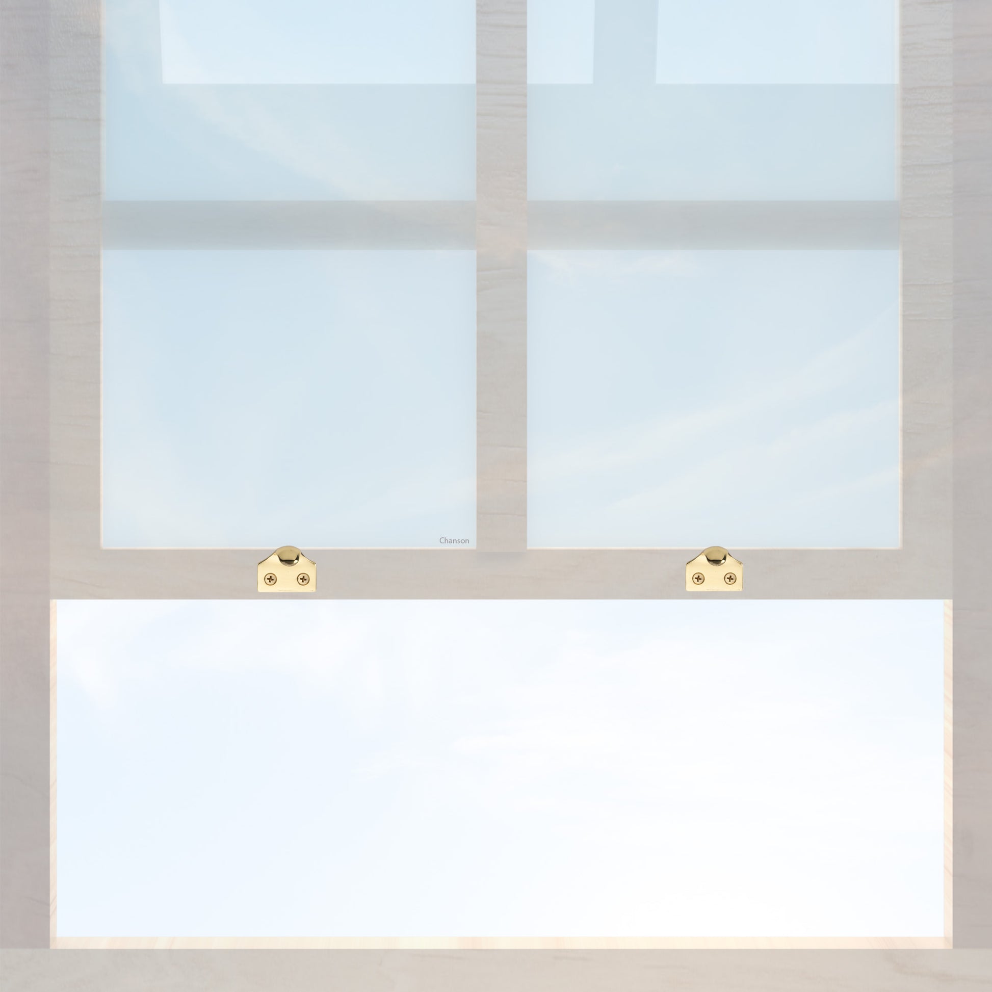 A wooden sash window with a pair of chanson hardware solid brass sash lifts that have a hook type design and an unlacquered brass finish