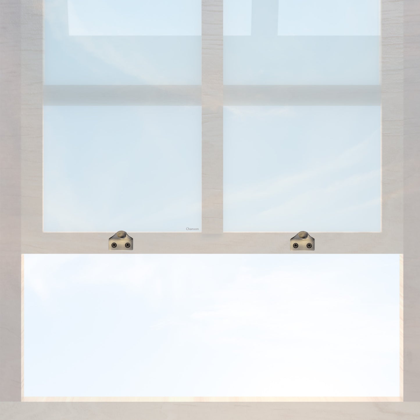 A wooden sash window with a pair of chanson hardware solid brass sash lifts that have a hook type design and an antique brass finish 