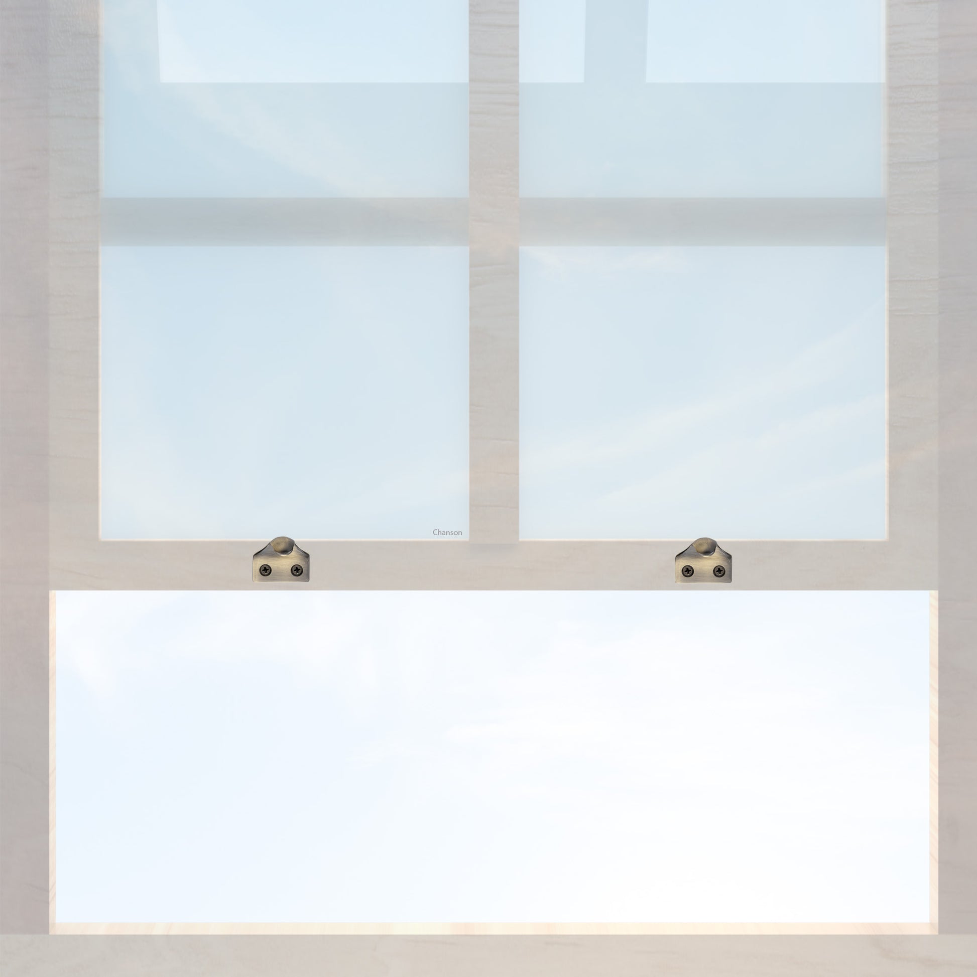 A wooden sash window with a pair of chanson hardware solid brass sash lifts that have a hook type design and an antique brass finish 