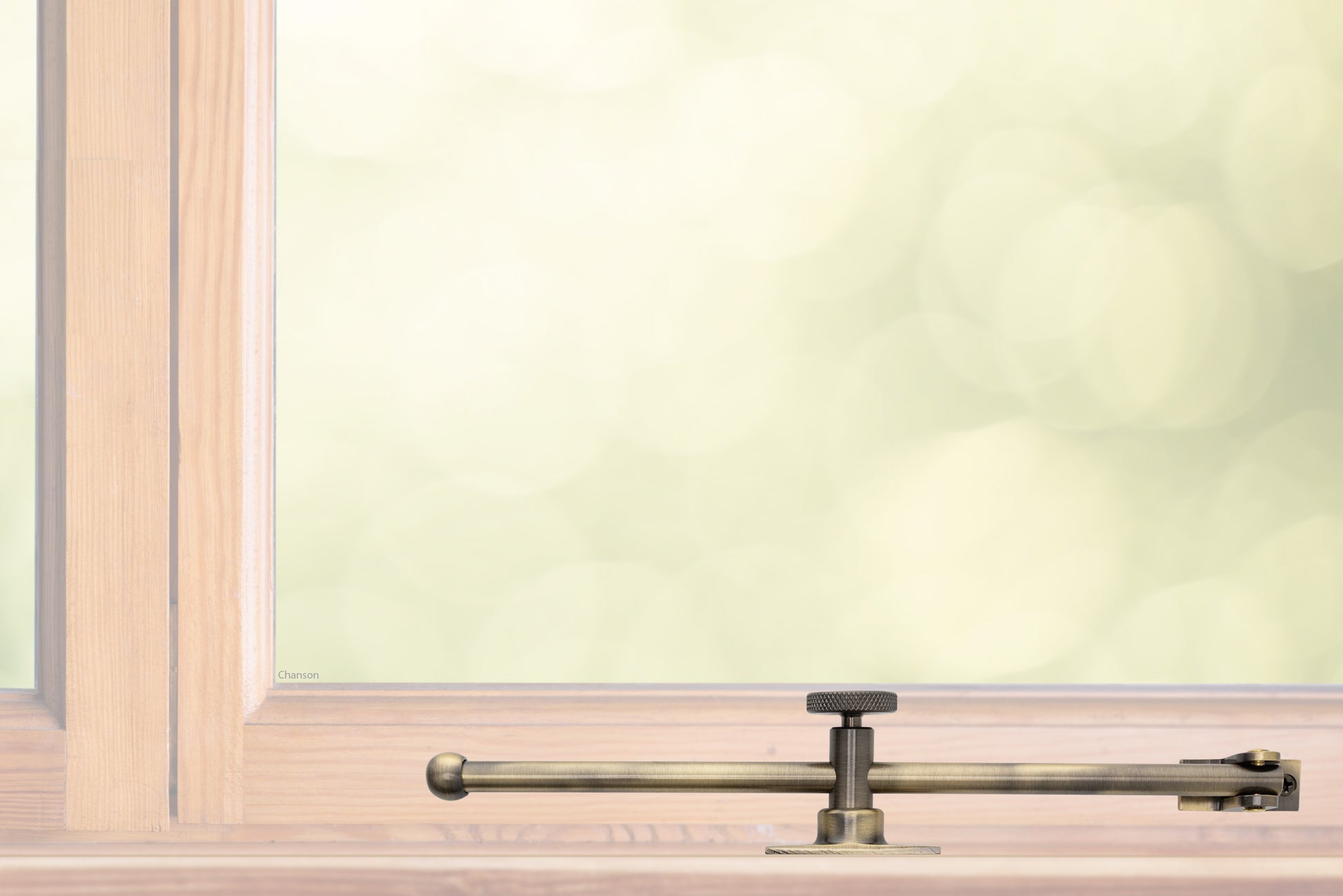 A sliding rod design solid brass casement adjustable stay with knob adjuster that is installed on the bottom sill or ledge of a outward swing window, shown in antique brass finish